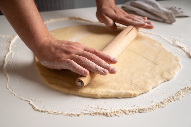 chef-stratching-dough-in-flour_23-2148343640.jpeg